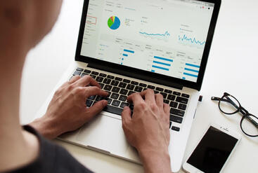 typing on laptop keyboard with Graph visible on screen